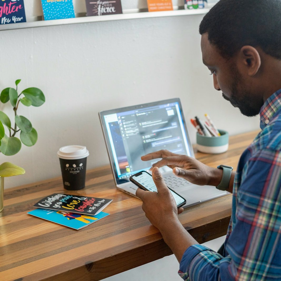 man in blue and red plaid dress shirt using silver ipad